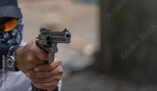 Man holding gun aiming pistol in hand ready to shoot. The criminal robber or gangster thief concept