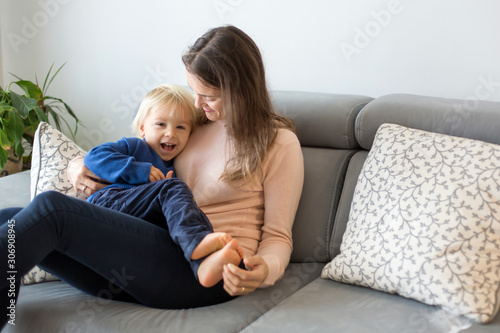 Mother, tickling her little toddler boy, child giggling at home