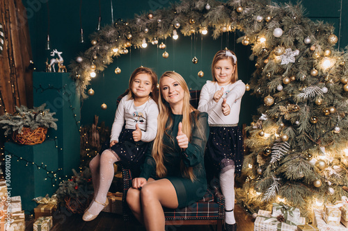 Close up portrait of cheerful happy cute caucasian girls playing with mother in merry christmas decorated holiday cozy home. Childhood, new year, kids leisure concept