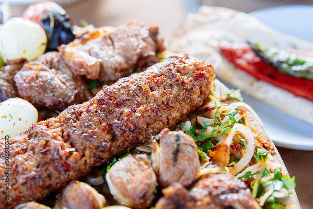 Traditional Turkish Adana kebab or kebap meat food, appetizers, raki and salgam on table from top view in turkish restaurant.	