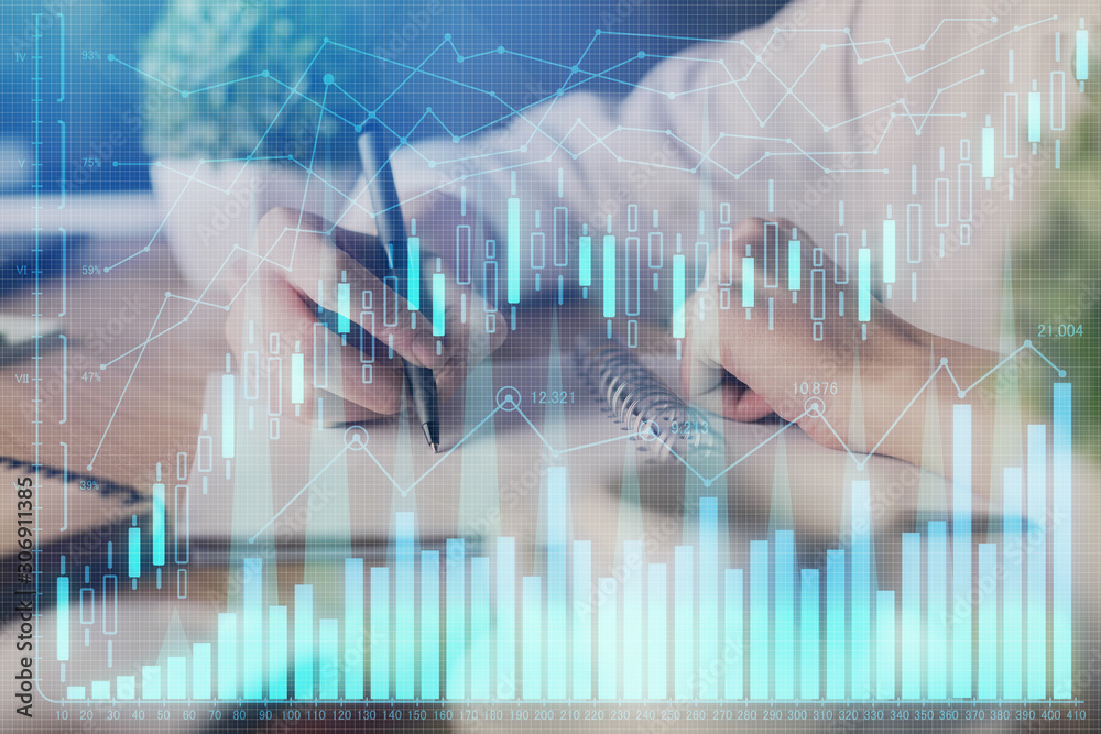Financial forex graph displayed on hands taking notes background. Concept of research. Multi exposure Financial forex graph displayed on hands taking notes background. Concept of research. Multi exposure