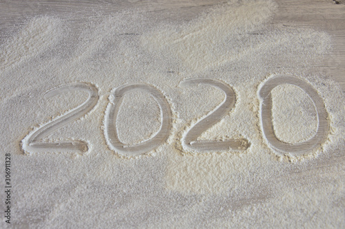 year 2020 written by hand on flour surface