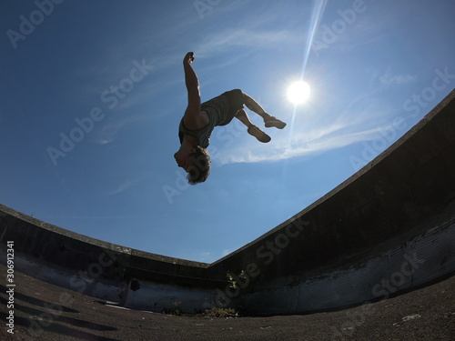 jeune athlète en salto arrière ayant le corps complètement dans le ciel photo