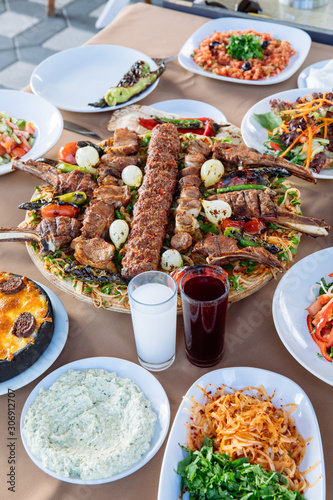 Traditional Turkish Adana kebab or kebap meat food, appetizers, raki and salgam on table from top view in turkish restaurant. 