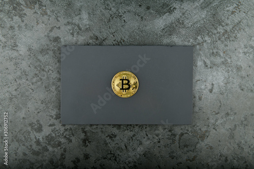 Bitcoin on a black background. place for an inscription. golden penny of bitcoin on marble.