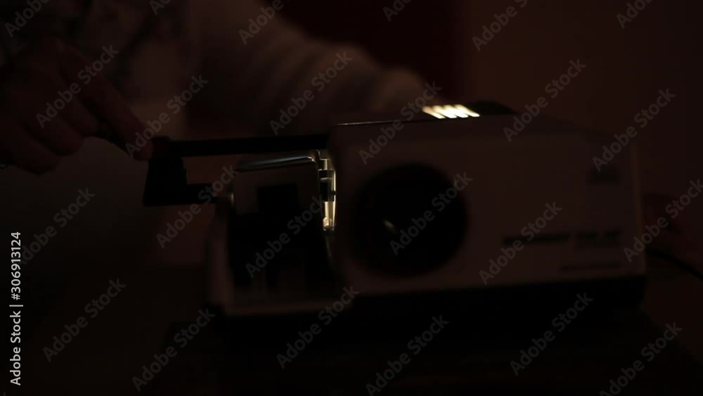 Old slide projector for close-up photos, changing color and blinking light. Slide projector. Retro styled slide projector in the dark room