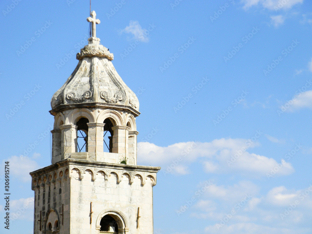 The close up of Saint Dominic Church bell tower in blue sky background, in old town Dubrovnik, Croatia.