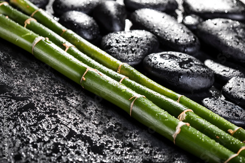 Bamboo with black zen stones on a black background. Spa concept