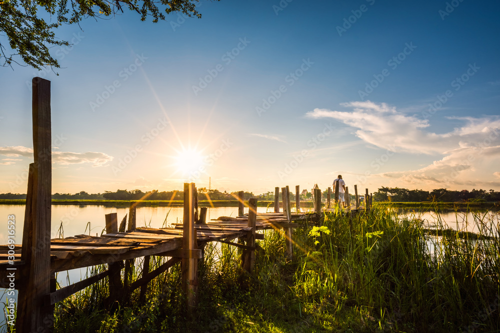 Obraz premium Man walking on wooden bridge