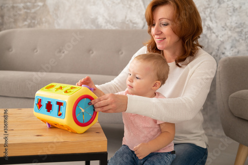 Photos Happy grandmother with toddler granddaughter is playing with sorter indoors