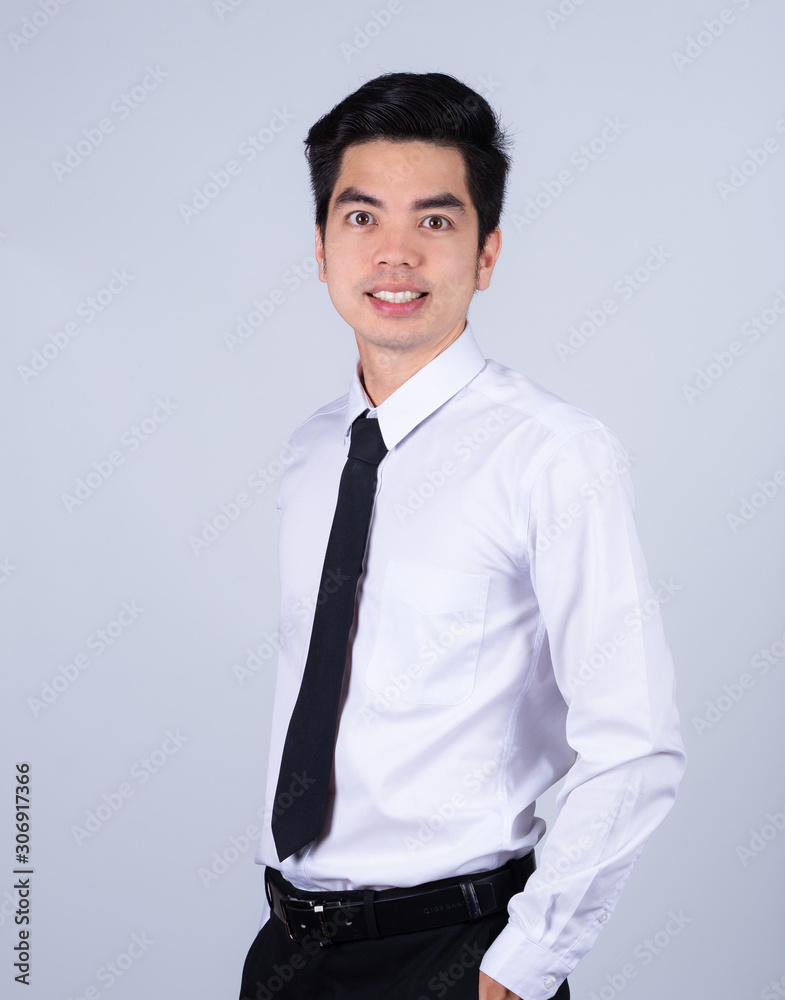 Fototapeta premium Portrait handsome young asian .businessman wearing a white shirt smile and look happy isolated on grey background in studio. Asian man people. 