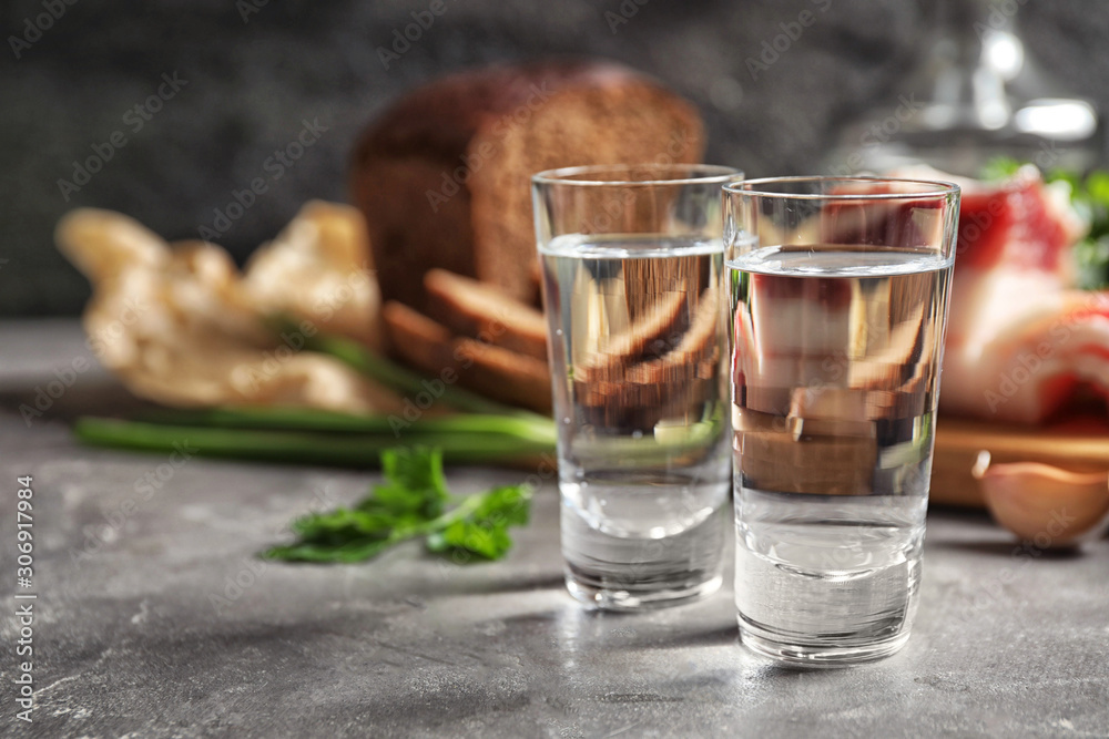 Cold Russian vodka with snacks on grey table, closeup Cold Russian vodka with snacks on grey table, closeup