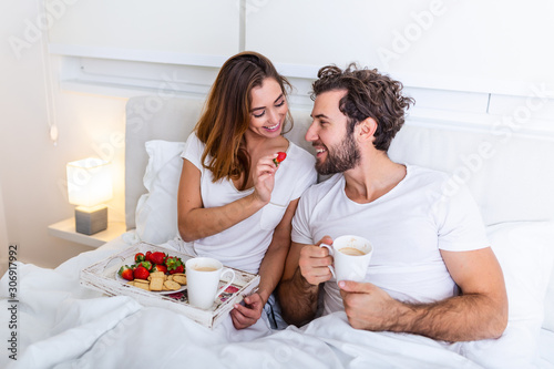 Vászonkép Cute couple having breakfast in bed in the bedroom