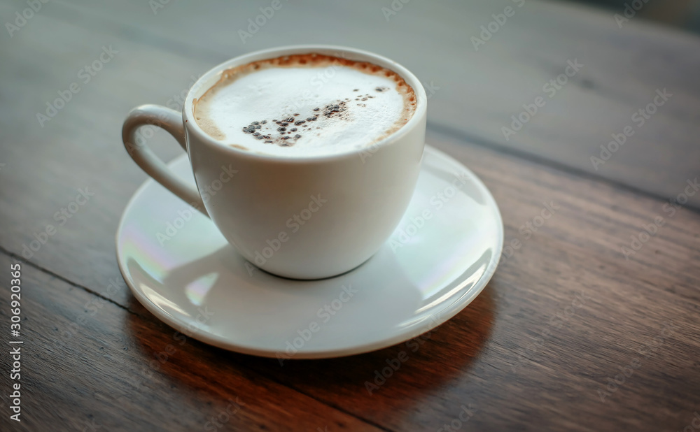 Blurred images of ready-to-drink cappuccino cups placed on a wooden table in the morning as background images and beautiful illustrations Blurred images of ready-to-drink cappuccino cups placed on a wooden table in the morning as background images and beautiful illustrations