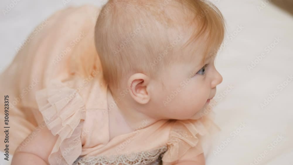 Beautiful Smiling Baby: A gorgeous little baby girl lies on white blanket and smiles at the camera with a nice big eyes. close up 4k video Beautiful Smiling Baby: A gorgeous little baby girl lies on white blanket and smiles at the camera with a nice big eyes. close up 4k video