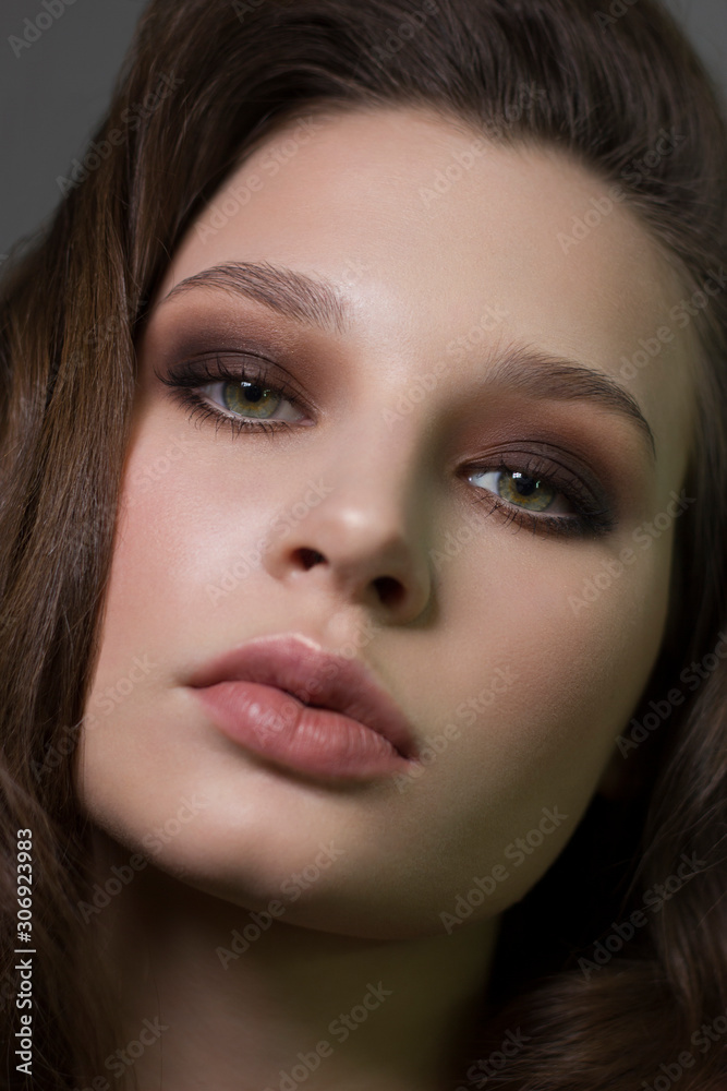 Close-up portrait of beautiful woman's purity face with dark green smoky-eyes make-up, pale full lips. Sexy model with clean shiny skin, purity complexion Close-up portrait of beautiful woman's purity face with dark green smoky-eyes make-up, pale full lips. Sexy model with clean shiny skin, purity complexion
