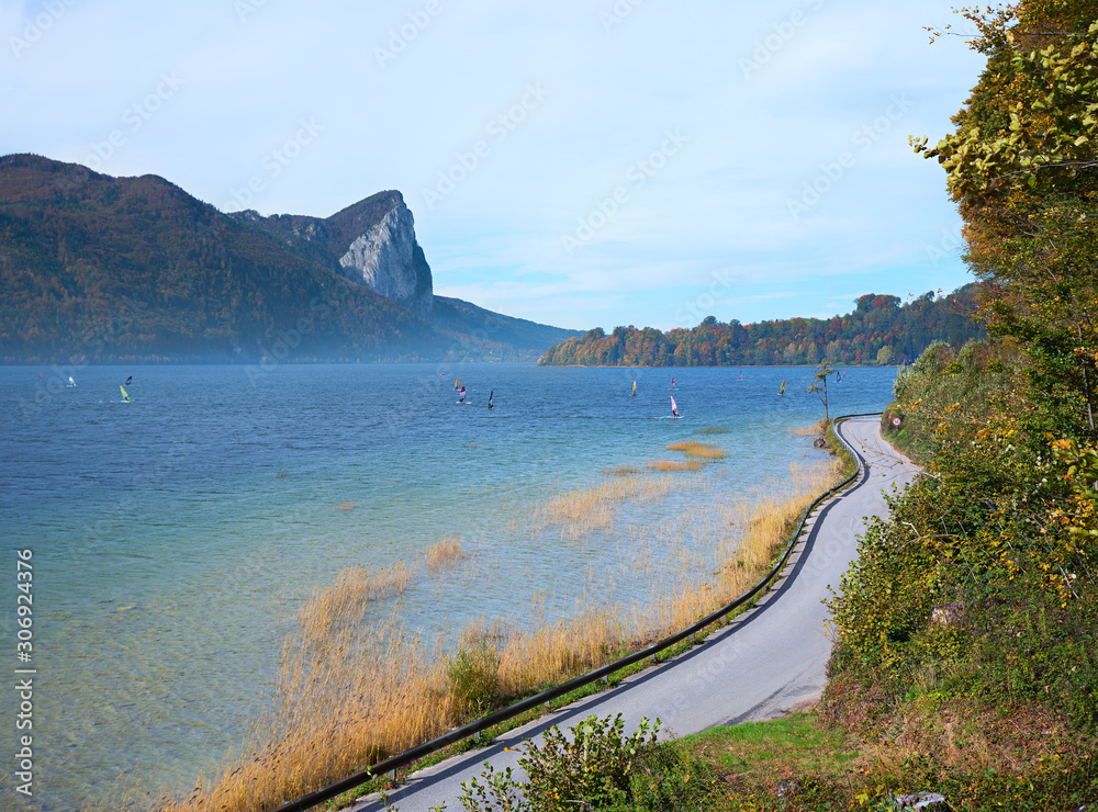 Obraz premium lakeside road lake Mondsee and mountains, group of windsurfers