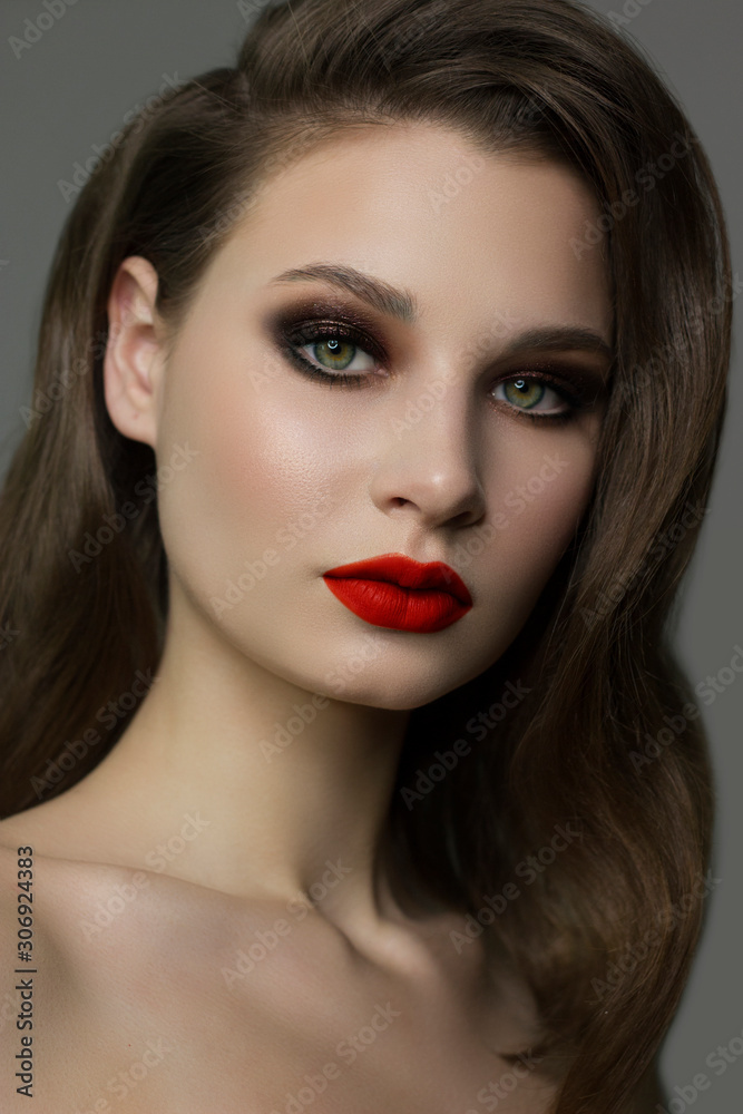 Close-up portrait of the cleanliness face of a beautiful woman with dark black smoky eyes makeup, red full lips. Sexy model with clean shiny skin, clean face, long curly hair. glamorous image Close-up portrait of the cleanliness face of a beautiful woman with dark black smoky eyes makeup, red full lips. Sexy model with clean shiny skin, clean face, long curly hair. glamorous image