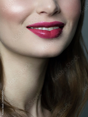 Close-up happy female smile with healthy white teeth  bright pink gloss lips make-up. Cosmetology  dentistry and beauty care. Macro of woman s smiling mouth