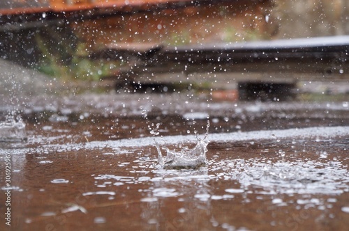Rain water drops falling on the floor in heavy rain day. © Brenda Blossom