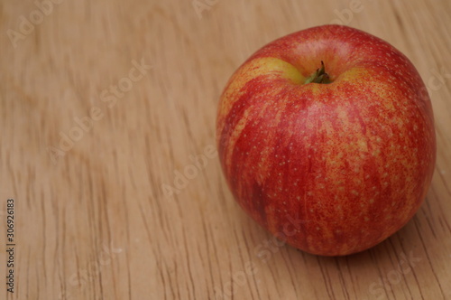 Close up of red apple on wood table background.