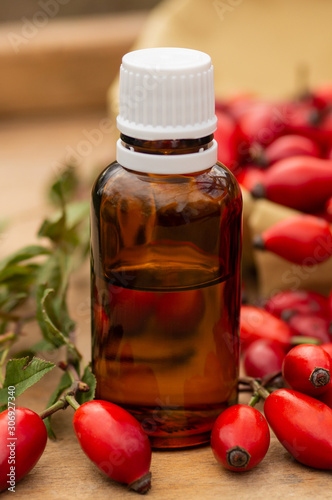 Rose-hips and rose hip seed oil on the wooden table. Rose hip  commonly known as rose hip (Rosa canina). 