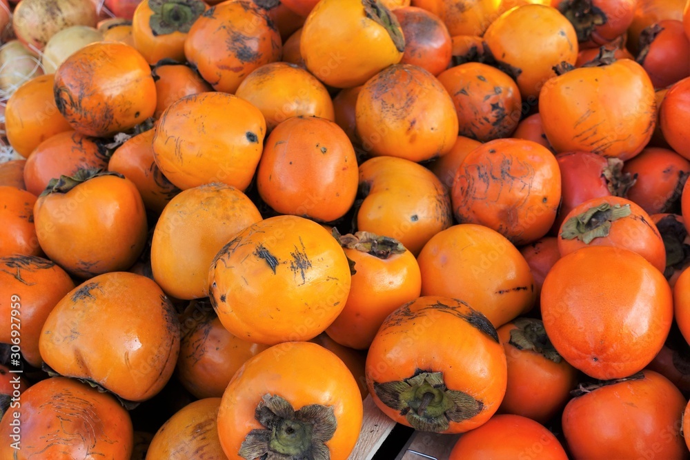 closeup of persimmons on display at the market closeup of persimmons on display at the market