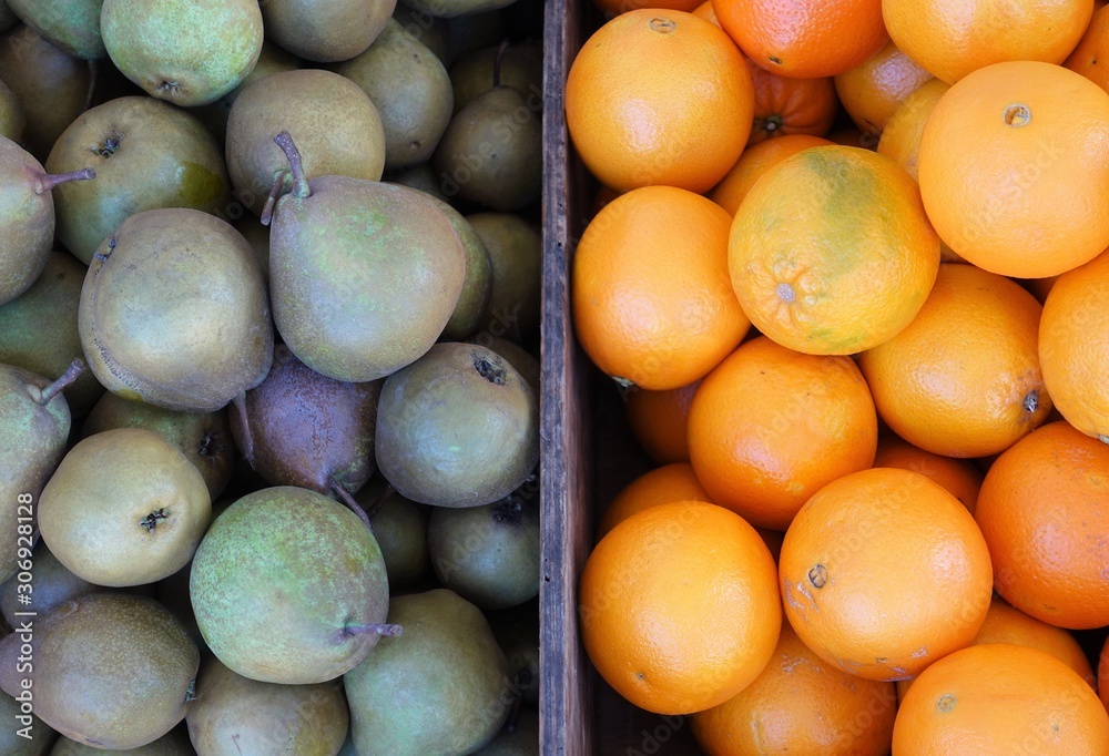 close-up of pears and oranges on display at the market