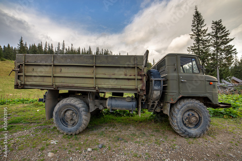Old all terrain truck with big protector rubber tires for off road use.