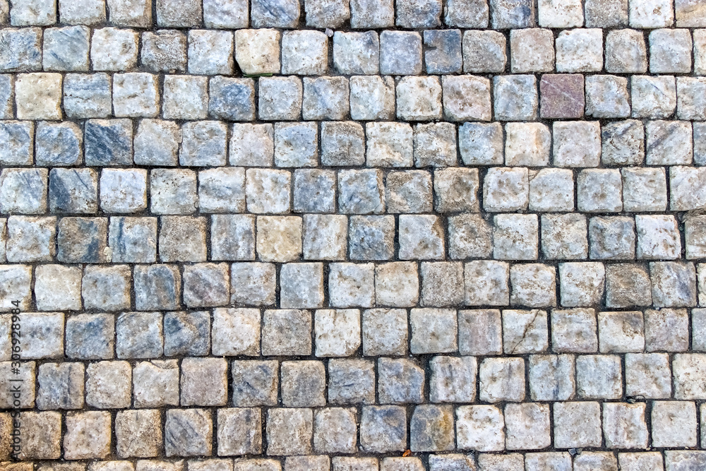 Obraz premium An old stoneblock pavement cobbled with square granite blocks