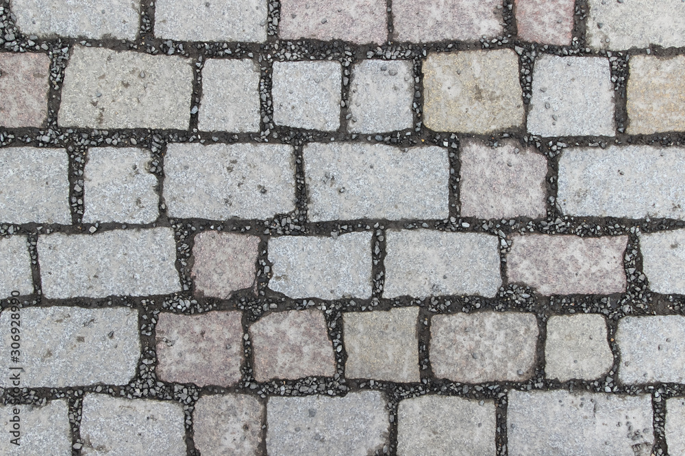An old stoneblock pavement cobbled with square stone blocks An old stoneblock pavement cobbled with square stone blocks