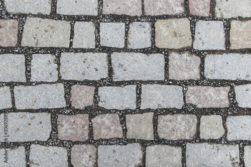 An old stoneblock pavement cobbled with square stone blocks