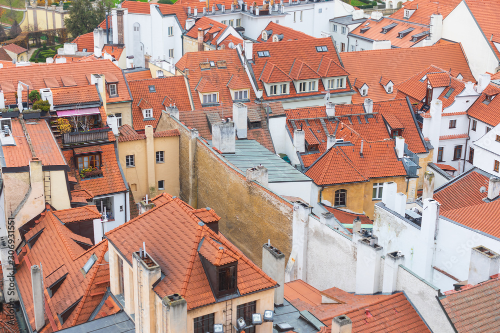 Prague white and yellow old houses with red roofs and chimneys, view from tower