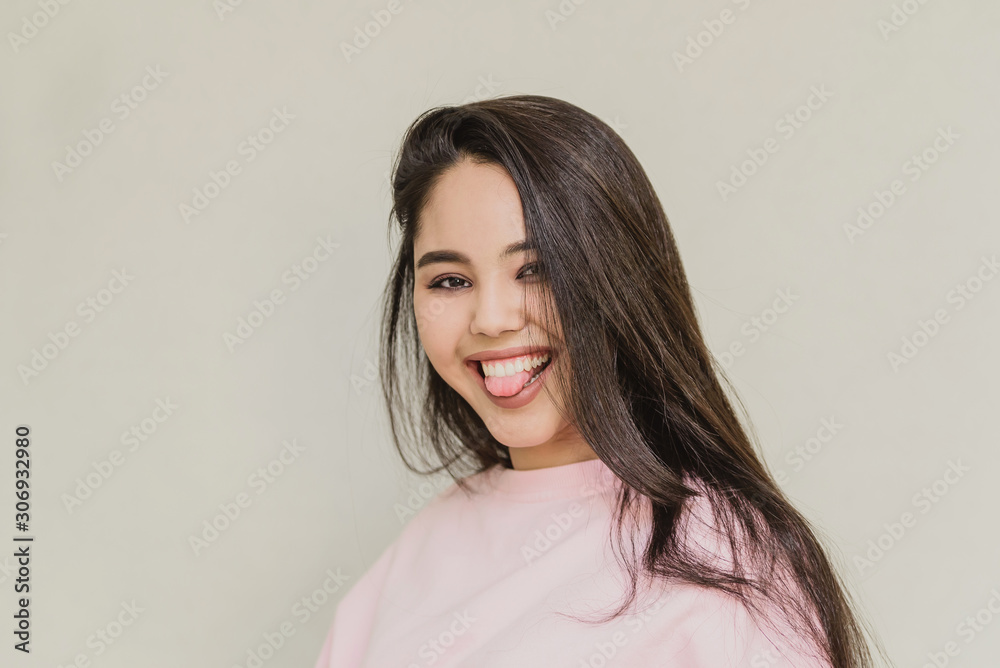 young attractive girl on white background. happy woman smiling. happy teen girl shows tongue young attractive girl on white background. happy woman smiling. happy teen girl shows tongue