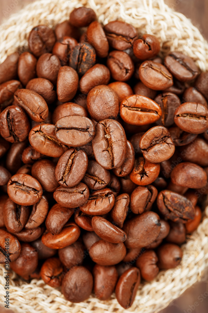 Coffee beans closeup in burlap bag on wooden background. Coffee beans closeup in burlap bag on wooden background.