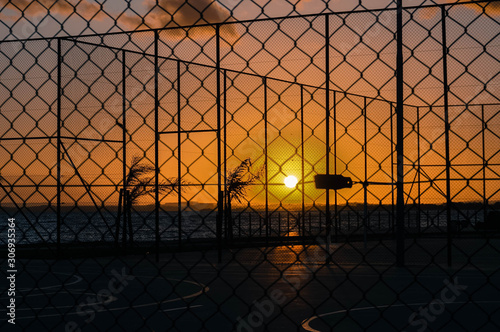 Pôr do sol em uma quadra de esportes no fim de tarde photo