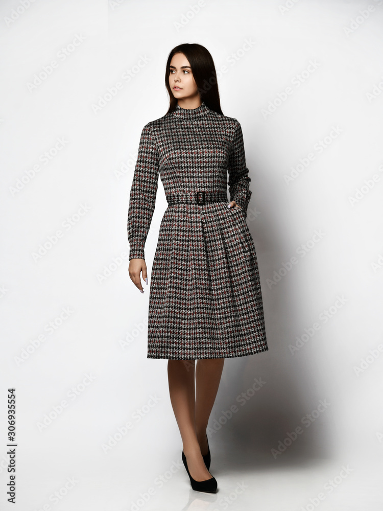 Young beautiful woman posing in new fashion long casual dark gray winter dress happy smiling walking full body Young beautiful woman posing in new fashion long casual dark gray winter dress happy smiling walking full body