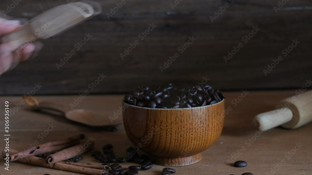Hand put a Wood spoon in to Hot black coffee bean with smoke in wood cup.Hand put a Wood spoon in to Hot black coffee bean with smoke in wood cup. Hand put a Wood spoon in to Hot black coffee bean with smoke in wood cup.Hand put a Wood spoon in to Hot black coffee bean with smoke in wood cup.
