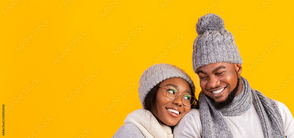 Black couple in love cuddling over yellow background Black couple in love cuddling over yellow background