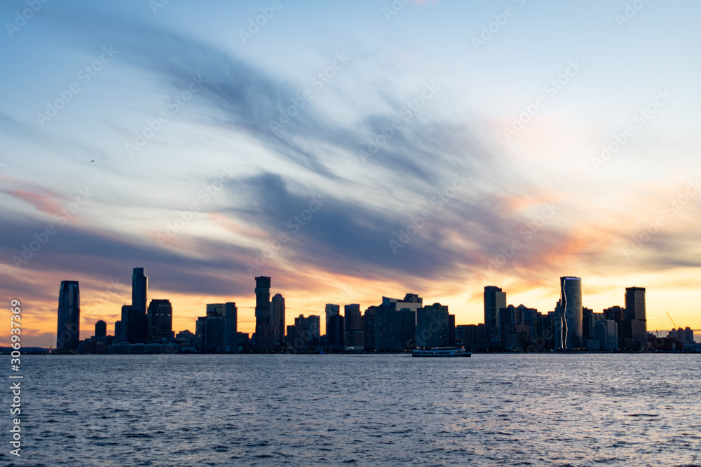 Jersey City Skyline along the Hudson River during a Sunset with a Ferry Boat