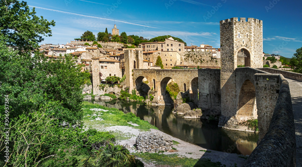 Medieval village Besalu with a stone arch bridge and towers - cityscape with old Spanish fortress. Famous historical landmarks of Catalonia with ancient architecture in romanesque style.