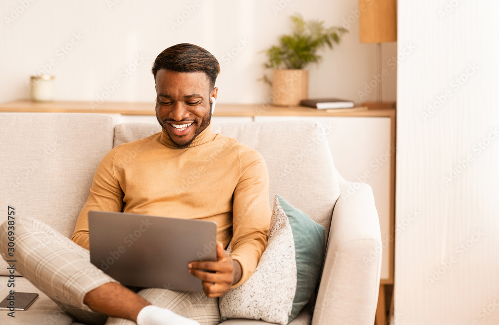 Man Using Laptop And Earbuds Making Video Call At Home Man Using Laptop And Earbuds Making Video Call At Home