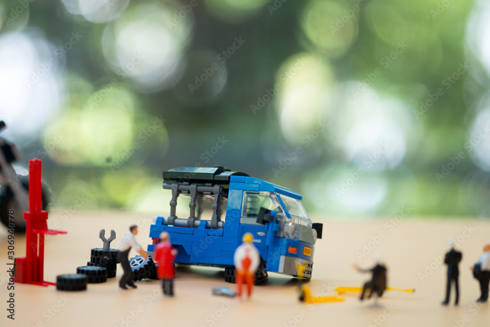 Miniature people: Workers fixing Thai car.