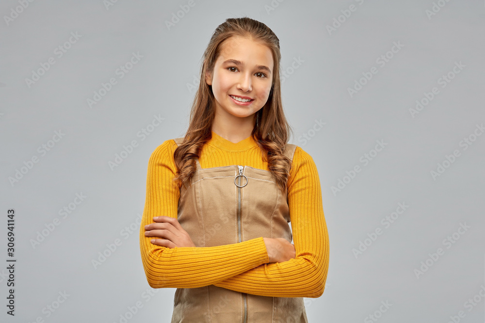 people concept - smiling young teenage girl with crossed arms over grey background people concept - smiling young teenage girl with crossed arms over grey background