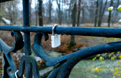 Close up of a love pad lock on a bridge fence in a park in Munich on a rainy day