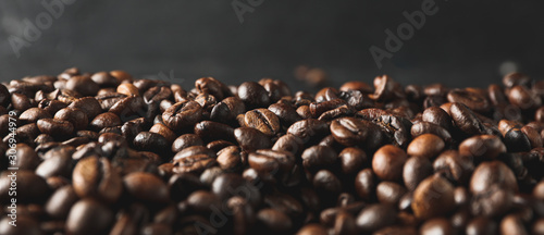 Coffee beans against black background, close up and space for text