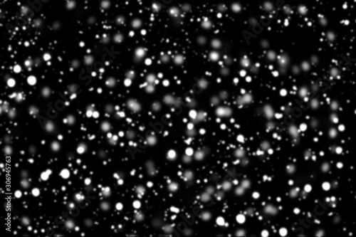 Texture of white snow blurry bokeh isolated black background. falling snow overlay. star sky. Black spots on white background, white drops and spots