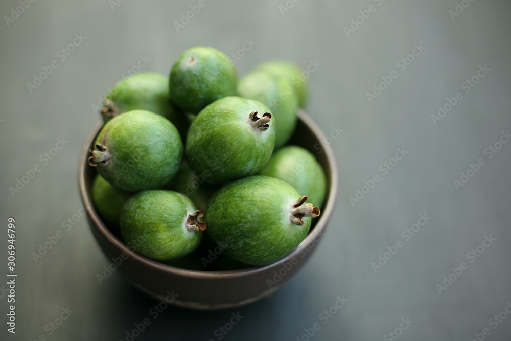 Feijoa green on black background. Feijoa Sellova is a fruit crop from tropical regions. Organic agricultural fruit, healthy food concept, eco-friendly natural products, vegetarian, raw harvest Feijoa green on black background. Feijoa Sellova is a fruit crop from tropical regions. Organic agricultural fruit, healthy food concept, eco-friendly natural products, vegetarian, raw harvest