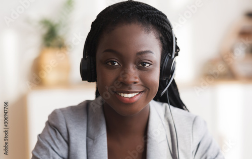 Fotografiet Portrait of black smiling female call center operator in headset
