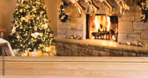 Wooden Empty Table - Background with Copy Space, Banner – in Blurred Interior of Beautiful Christmas Festive Golden Room Design with Fireplace and Christmas Tree. 
